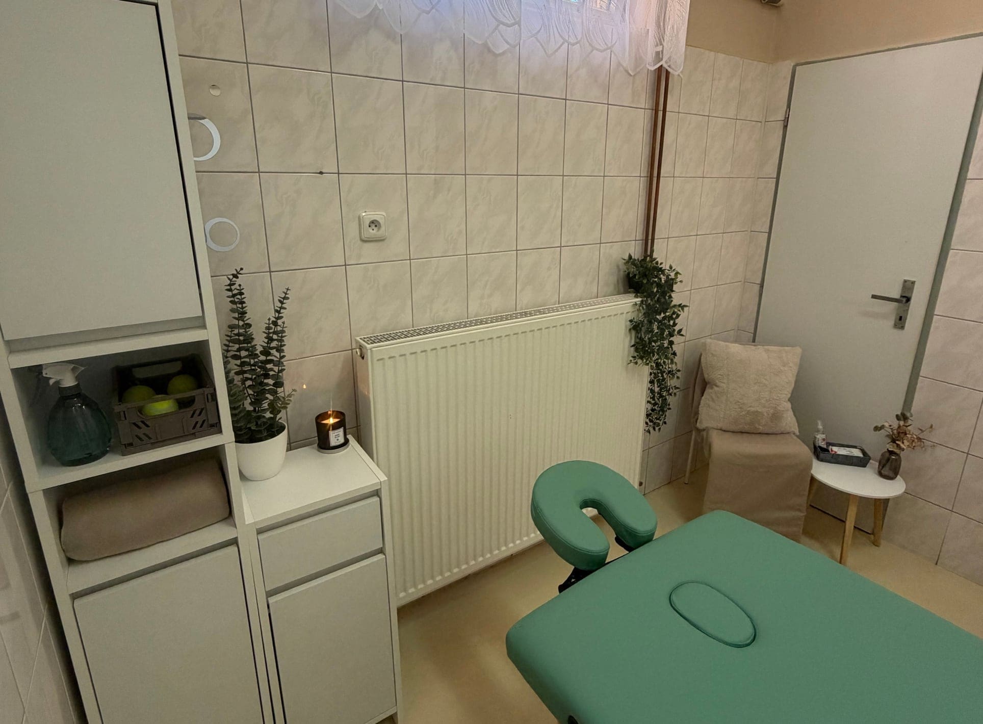 Masérna salonu Verona ve Strakonicích – zelený masážní stůl, polička s ručníky a svíčka